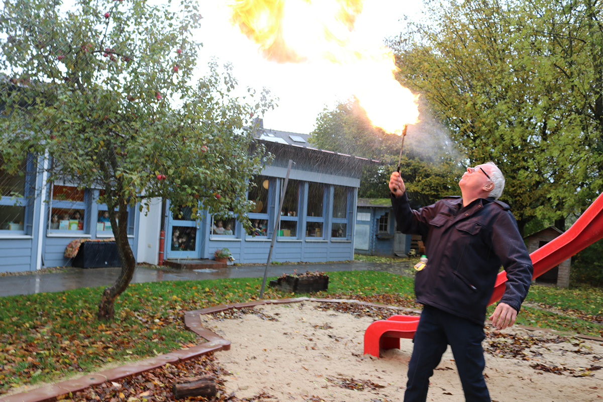 IMG_7748x_Feuer_Kita_ASB_FvB_C5.jpg Eindrucksvoll für die Zuschauer hinter den fenstern: Holger Stemmer vom FvB zeigte sein Können als Feuerspucker im Kita-Garten.